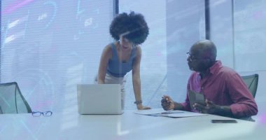 Kadın masaya yaslanıyor ve erkek dizüstü bilgisayar kullanıyor, iş toplantılarında tablet kullanıyor, animasyon çizelgeler sergiliyor. İşbirliği, takım çalışması, modern, profesyonel, yenilik, iletişim, teknoloji