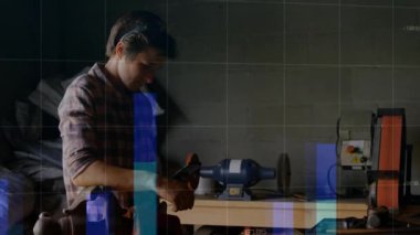 Teknoloji atölyesindeki adam, dijital şebeke haritasını ve değişen çizgi grafiklerini düzenliyor. Sanatçı, atölye, sanayi, kesinlik, mühendislik, yenilik, çalışma alanı