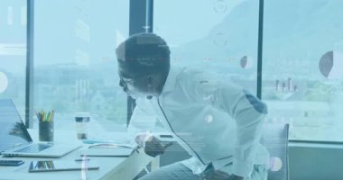 Masada oturan erkek profesyonel, finans için animasyon bar ve pasta grafiklerini izliyor. İş, üretkenlik, modern, teknoloji, işbirliği, yenilik, veri