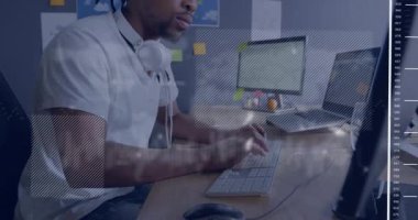 Teknoloji ofisindeki masaüstü bilgisayarında yazı yazan bir adam. Yapışkan notların etrafında hareketli akış şeması sembolleri var. Teknoloji, çalışma alanı, modern, üretkenlik, yenilik, iletişim, dijital