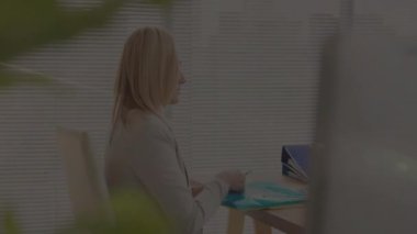 İş kadını masadaki deniz mavisi dosyasına danışmanlık yapıyor. Canlandırılmış veri tablosu ve lens fişeği var. Profesyonel, çalışma alanı, minimalist, veri, kurumsal, üretkenlik, modern