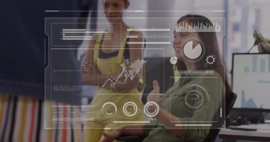 İki kadın, dünya haritası ve haritalarını gösteren animasyon paneliyle iş ofisinde işbirliği yapıyor. Teknoloji, işbirliği, yenilik, veri görselleştirme, işyeri, fütürizm, takım çalışması