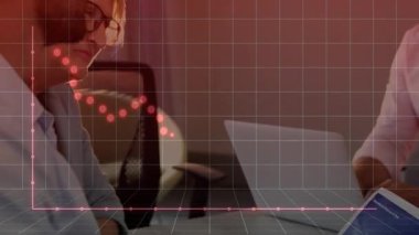 Dizüstü bilgisayarda finans verilerini analiz eden iki erkek meslektaşımız kırmızı noktalı grafiği gösteriyor. İş, takım çalışması, dijital, teknoloji, işbirliği, analitik, şirket