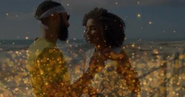 Kumsalda kucaklaşan bir çift, yüzen kalp ikonlarıyla sosyal medya pazarlamasını resmediyor. Romantizm, şefkat, huzur, rahatlık, yaşam tarzı, sıcak, canlı