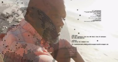 Sahilde oturan bir adam, kod parçacıklarıyla ufka doğru bakıyor, teknoloji için nokta desenleri. Dijital, düşünceli, sakin, modern, fütüristik, rahat, şık