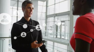 Kıdemli yönetici iş lobisinde yüzen ağ simgelerini gösteren bir tabletle konuşuyor. Profesyonel, ağ oluşturma, işbirliği, teknoloji, modern, kurumsal, iletişim