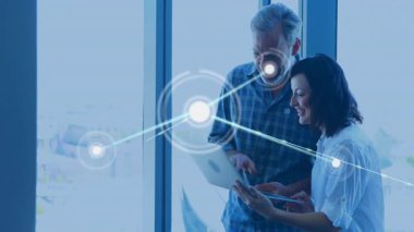 İki meslektaş, veri akışını gösteren ağ haritalı ofis araçlarını kullanarak iş verilerini analiz ediyor. Teknoloji, işbirliği, yenilik, bağlantı, modern, profesyonel, iletişim