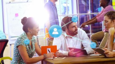 Ofisteki ahşap masa etrafında iş birliği yapan iş ekibi yüzen sohbet ve tablet simgelerini gösteriyor. Takım çalışması, yenilik, modernlik, iletişim, şirket, beyin fırtınası, üretkenlik