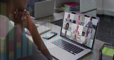 Ofisteki meslektaşım ahşap masada sanal iş toplantısına katılıyor ve animasyon çizelgeleri gösteriyor. İşbirliği, uzak, çalışma alanı, modern, dijital, iletişim, çeşitlilik