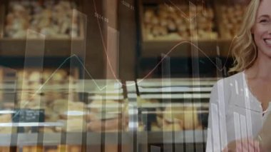 Kadın fırın müşterisi kredi kartı ve baget tutuyor, yüzen finansal tabloları gösteriyor. Perakende, ticaret, tüketim, kentsel, modern, canlı, yaşam tarzı