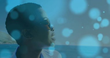 Sahilde gülümseyen yansıtıcı güneş gözlüğü takan kadın, seyahat pazarlaması için yüzen sahte ışıklar. Macera, eğlence, tatil, rahatlama, manzara, doğa, canlı