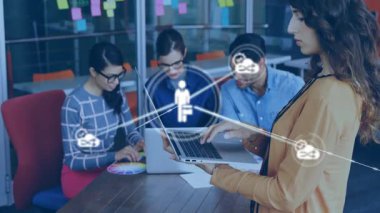 Ekip ofisteki teknoloji projesi için renk çarkı kullanıyor. Laptop ve bulut simgeleri üzerinden bilgi alışverişinde bulunuyor. İşbirliği, yenilik, takım çalışması, modernlik, bağlantı, dijital, beyin fırtınası