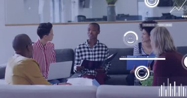 Ofis salonundaki iş toplantısına katılan bir grup iş arkadaşı dijital veri tablolarını tartışıyor. İşbirliği, takım çalışması, yenilik, modern, profesyonel, iletişim, çalışma alanı