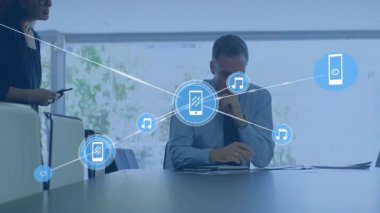 Ofisteki meslektaşlarına dijital ağ telefonu ve müzik ikonları gösteren iş verilerini sunan bir kadın. İşbirliği, iletişim, dijital, teknoloji, profesyonellik, yenilik, ağ