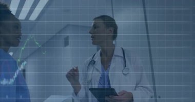 Kadın doktor tableti inceliyor ve hemşire koridordaki dosyaları inceliyor, üzerinde finans grafikleri var. Tıbbi, sağlık, tanı, analiz, profesyonellik, yenilik, veri