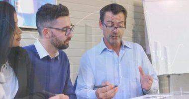 İş arkadaşları masada oturup finans verilerini tartışıyor, yüzen dijital grafikler gösteriyorlar. Kurum, işbirliği, profesyonellik, analitik, strateji, modernlik, takım çalışması