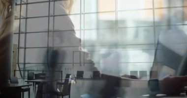 Kadın transit lobide dizüstü bilgisayarı tıklatıyor, yüzen teknoloji grafiklerini siluetin üzerinde gösteriyor. Siluet, modern, kentsel, minimalist, teknoloji, çalışma alanı, sükunet