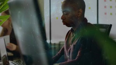 İşyerindeki bilgisayarda çalışan bir adam yapışkan notların üzerinde süzülen animasyon çizelgelerini gösteriyor. Profesyonel, işbirliği, üretkenlik, canlı, çağdaş, yenilik, takım çalışması