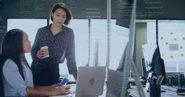 Masada işbirliği yapan iki kadın, iş için yüzen animasyon çizelgeleri ve renk simgeleri sergiliyorlar. İşbirliği, çalışma alanı, modern, profesyonel, teknoloji, üretkenlik, takım çalışması