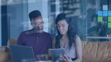 Tablet tutan kadın ve dizüstü bilgisayarda yazan adam, cam üzerinde yapışkan notlar olan teknoloji kodlarını gösteriyor. İşbirliği, yenilik, modern, üretkenlik, takım çalışması, dijital, yaratıcılık