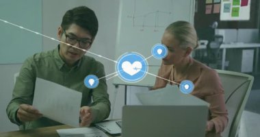 Ofiste evrakları inceleyen iki meslektaş, veri içgörülerini vurgulayan yüzen IOT simgeleri. İşbirliği, takım çalışması, yenilik, teknoloji, analitik, iş dünyası, modernite