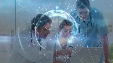 Klinikte dizüstü bilgisayar üzerinde işbirliği yapan tıbbi ekip holografik küreyi ve veri noktalarını tasarlıyor. Sağlık, işbirliği, teknoloji, yenilik, kesinlik, analitik, profesyonellik