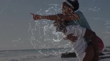 Sahilde kadın taşıyan bir adam holografik düğümleri ve çizgileri olan bir teknoloji ağı sergiliyor. Bağlantı, yenilik, bağlantı, teknoloji, iletişim, meditasyon, canlılık