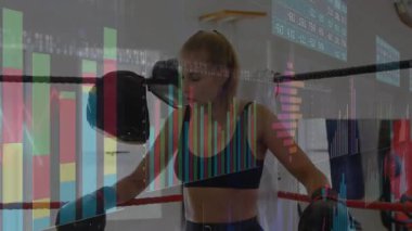Boks salonunda halatlara yaslanmış kadın boksör, finans çubuğu grafikleri ve çizelgeleri gösteriyor. Sporcu, fitness, power, determination, motivasyon, güçlendirme, eğitim