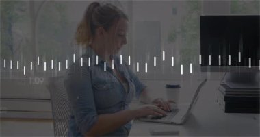 Ofiste bilgisayarında akıllı telefonuyla yazıp teknoloji veri tablolarını gösteren yetişkin bir kadın. İş, üretkenlik, modern, çalışma alanı, dijital, yenilik, iletişim