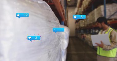 Depo çalışanı, lojistik sahnesinde yüzen sosyal medya simgelerini gösteren paletleri tarıyor. Sanayi, lojistik, envanter, işletme, verimlilik, güvenlik, teknoloji