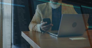 Kıdemli teknisyen masasında oturmuş elinde akıllı bir telefonla uçan kodlu dizüstü bilgisayar seyrediyor. Teknoloji, profesyonel, yenilik, kodlama, iş yeri, işyeri, modern