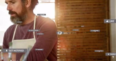 Mutfakta yemek pişiren yaşlı kadın ve yetişkin adam, mutfak aletlerinin üzerinde yüzen sosyal medya simgelerini gösteriyor. Aile, yemek pişirme, sosyal medya, dijital, işbirliği, modern, yaşam tarzı