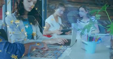 Çalışma ekibi çalışma masasında iş birliği yapıyor, dizüstü bilgisayarda yazı yazıyor ve tableti işaret ediyor, altın yıldızları gösteriyor. Profesyonel, takım çalışması, modern, yenilik, iletişim, çalışma alanı, canlı