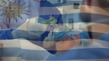 Hasta bakıcı kadın Uruguay bayrağı ve monitörünü kapatırken hastane koğuşunda cankurtaran çantası kullanıyor. Tıbbi, acil, klinik, sağlık, müdahale, kurtarma, güvenlik