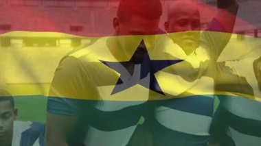 Futbol takım arkadaşları stadyumda kucaklaşıyorlar, spor pazarlama grafikleri üzerinde bayrak kaplamaları var. Zafer, takım çalışması, kutlama, canlı, enerjik, açık hava, sportmenlik