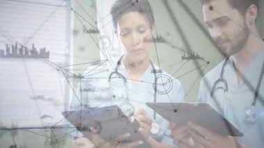 Kadın sağlık çalışanı panoyu tutarken erkek meslektaşı tablet kullanarak ağ grafiğini gösteriyor. Tıbbi personel, işbirliği, dijital sağlık, profesyonel, sağlık, iletişim, modern