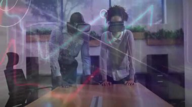 VR kulaklık takan erkek ve bayan meslektaşlar toplantı masasına yaslanıp iş bilgileri çizelgesini görüyorlar. Teknoloji, işbirliği, yenilik, şirket, fütürizm, dijital, profesyonel