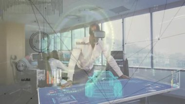 Stüdyoda dijital masaya yaslanmış VR kulaklık kullanan erkek mühendis ağ grafiklerini örtüyor. Teknoloji, işbirliği, yenilik, fütüristik, ofis, dijital, çalışma alanı