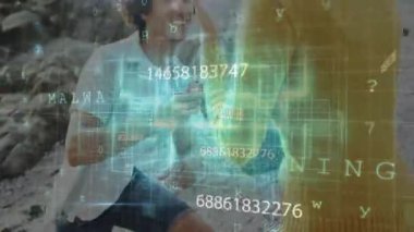 Rocky Sahili 'nde diz çökmüş bir adam teknolojik tasarım için yüzen numaraları ve şebeke hatlarını gösteriyor. Romantik, evlilik teklifi, kutlama, açık hava, manzara, yenilikçi, sevgi dolu