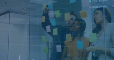 Cam duvarın arkasına canlı finansal çizelgelerle yapışkan notlar yerleştiren üç ofis çalışanı. İşbirliği, takım çalışması, strateji, yenilik, veri görselleştirme, çalışma alanı, modern