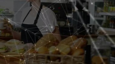 Kahve barmeninin kahve tezgahını sandviçlerle doldurup ağ örtüşmesi gösteren kadın. Kafe, misafirperverlik, köylü, sıradan, sıcak, hizmet, konforlu