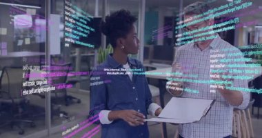 Açık planlı ofiste yazılım kodlarını tartışan iş arkadaşları, yüzen kodlar arasında kağıtları tutuyorlar. Teknoloji, işbirliği, yenilik, çalışma alanı, dijital, iletişim, üretkenlik