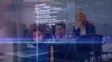 Ekip ofiste monitör etrafında işbirliği yapıyor, animasyon tabloları ve ikili kodlar tasarlıyor. İşbirliği, finans, teknoloji, veri, yenilik, takım çalışması, analiz