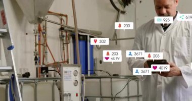 Sanayi odasında tablet kullanan kıdemli teknisyen, sosyal medya simgeleri borularda yüzüyor. Sanayi, teknoloji, mühendislik, bakım, yenilik, dijital, profesyonel