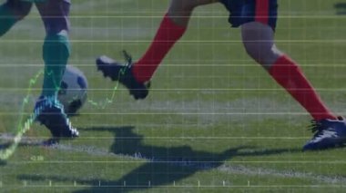 Erkek sporcular çimen sahasında topa karşı mücadele ediyorlar ve finans şamdanı grafikleriyle birlikte. Atletizm, spor, rekabet, takım çalışması, enerji, strateji, fitness