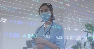 Elinde tablet bulunan maskeli sağlık çalışanı üçgen ve sayılarla finansal verileri gösteriyor. Tıbbi profesyonel, dijital arayüz, steril ortam, sağlık teknolojisi, veri görselleştirme, klinik ortam, profesyonel kıyafet