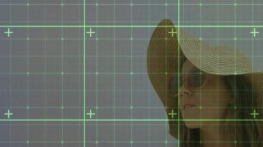 Plajda hasır şapka ve güneş gözlüğü takan bir kadın seyahat için yeşil şebeke örtüsü sergiliyor. Sahil, yaz, boş zaman, açık hava, tatil, huzur, doğa.