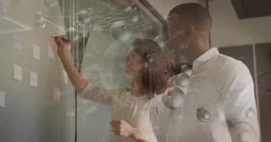 Erkek meslektaşım, pastel satışlar ile finans tahtasını işaretliyor. Yapışkan notlar, yüzen düğümler. İşbirliği, takım çalışması, yenilik, şirket, danışmanlık, veri, strateji