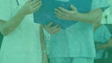 Hastanedeki hasta dosyasını inceleyen iki tıbbi personel canlandırılmış kalp ikonu ve veri tablosu gösteriyor. Sağlık, takım çalışması, profesyonellik, klinik, tanı, tıbbi ortam, güvenlik