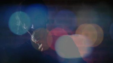 Sahnede mikrofonla şarkı söyleyen erkek şarkıcı yüzen bokeh ile müzik endüstrisini sergiliyor. Performans, müzik, gece hayatı, konser, ambians, sahne, sanatçılık